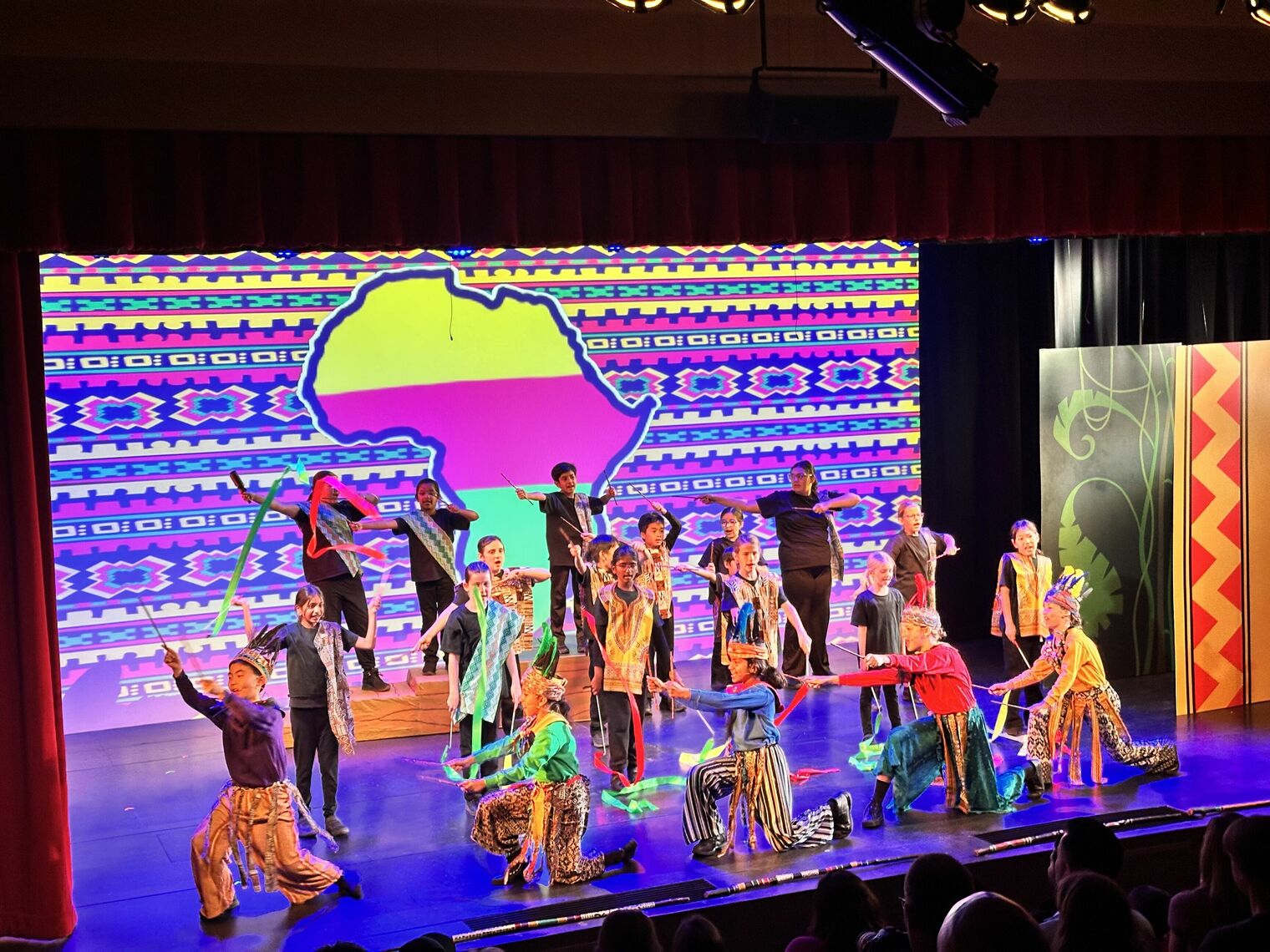 stage full of young students performing Lion King Jr.