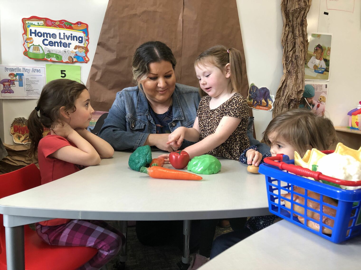 Photo of preschool students and teacher with plastic fruits and vegetables