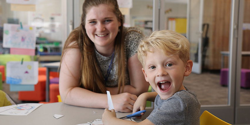 smiling kindergarten student with teacher
