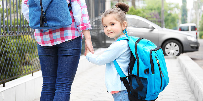 child walking to school with adult