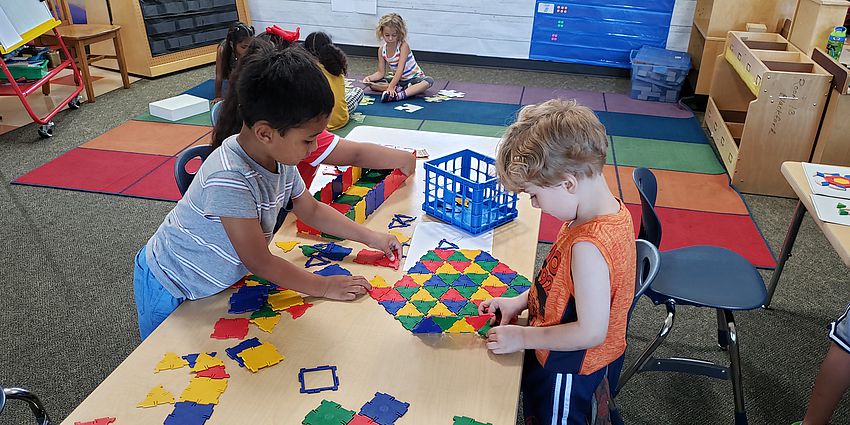 Two students working on a geometric math centers. 