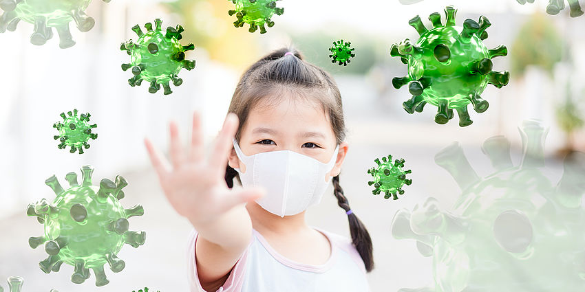 young girl wearing mask. hand pushes away germs