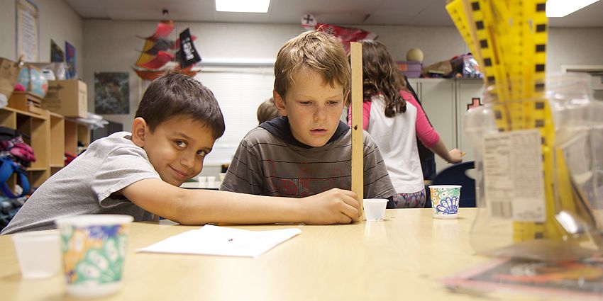 boy holding ruler and smiling at camera