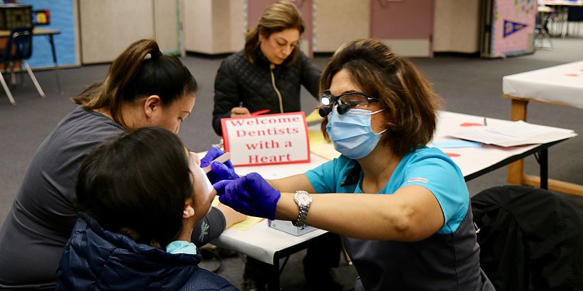 dentist checks a student's teeth