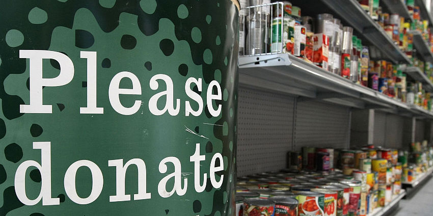 Picture of food donation bin and canned food on shelves