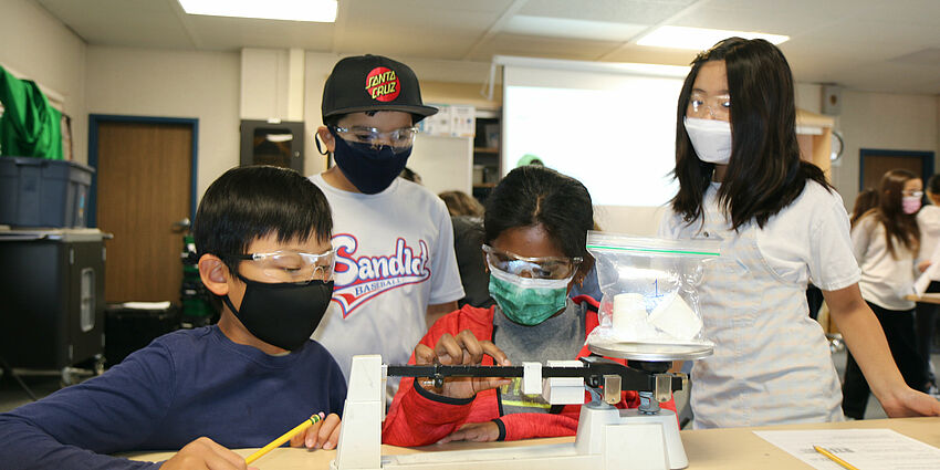 four students work an experiment at school