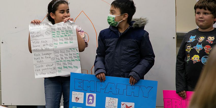 students standing with signs and survey data