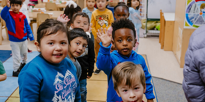 Preschool students at the Family Learning Center wave for the camera