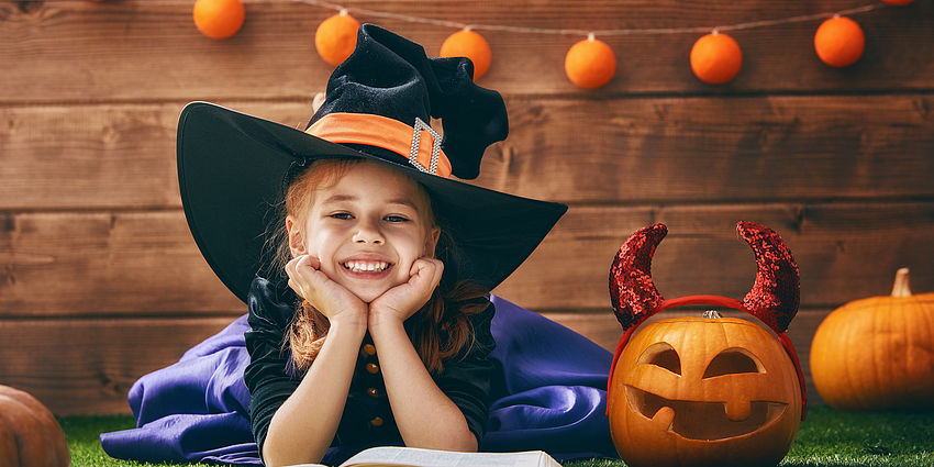 Young girl with witches hat on and a jackolantern