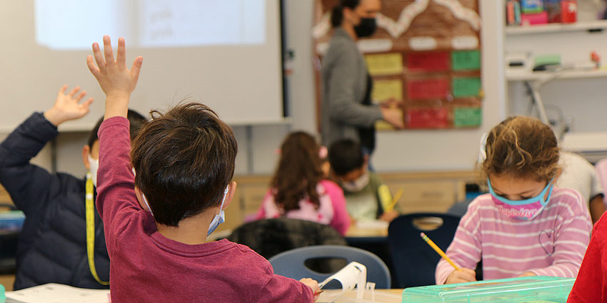 student raising hand in class