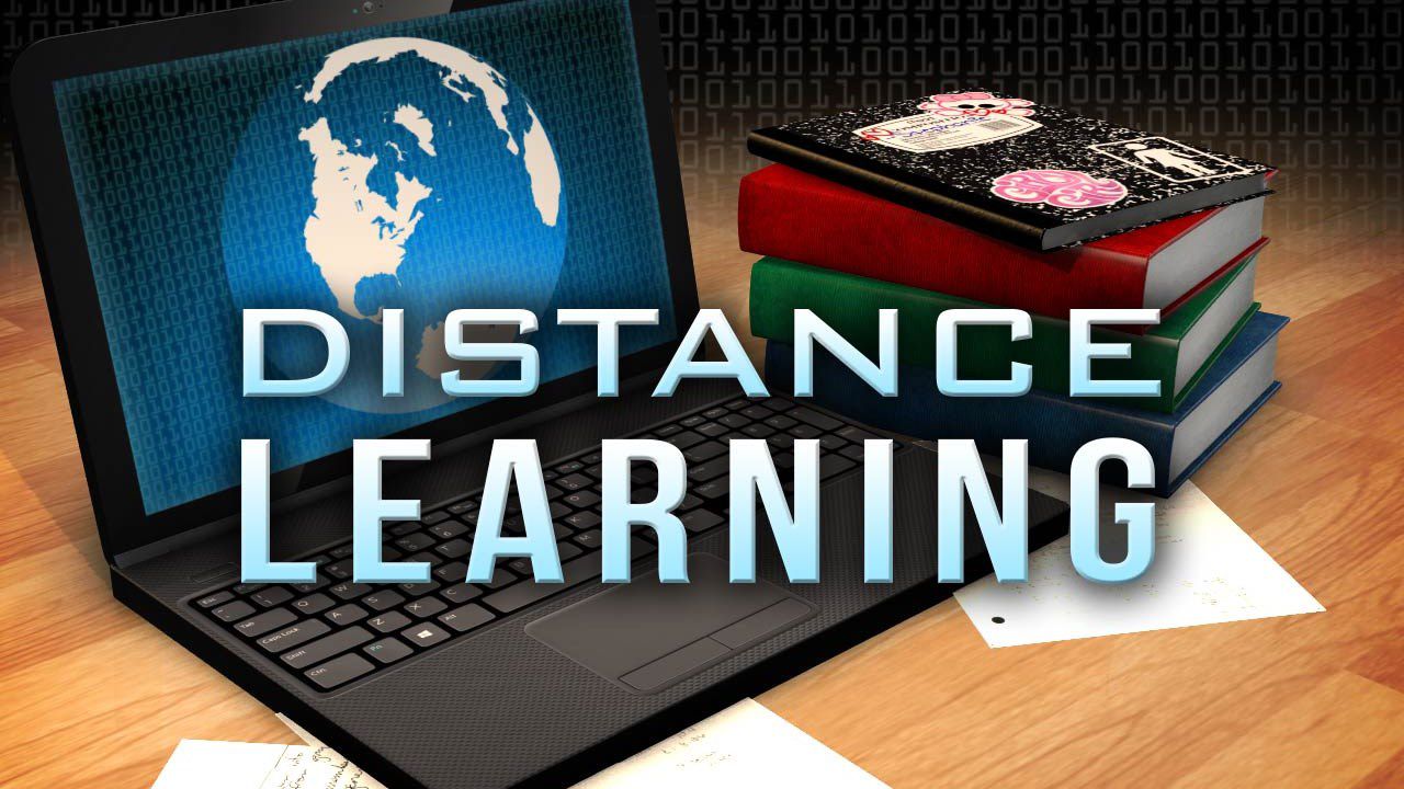an open laptop with books and words distance learning 