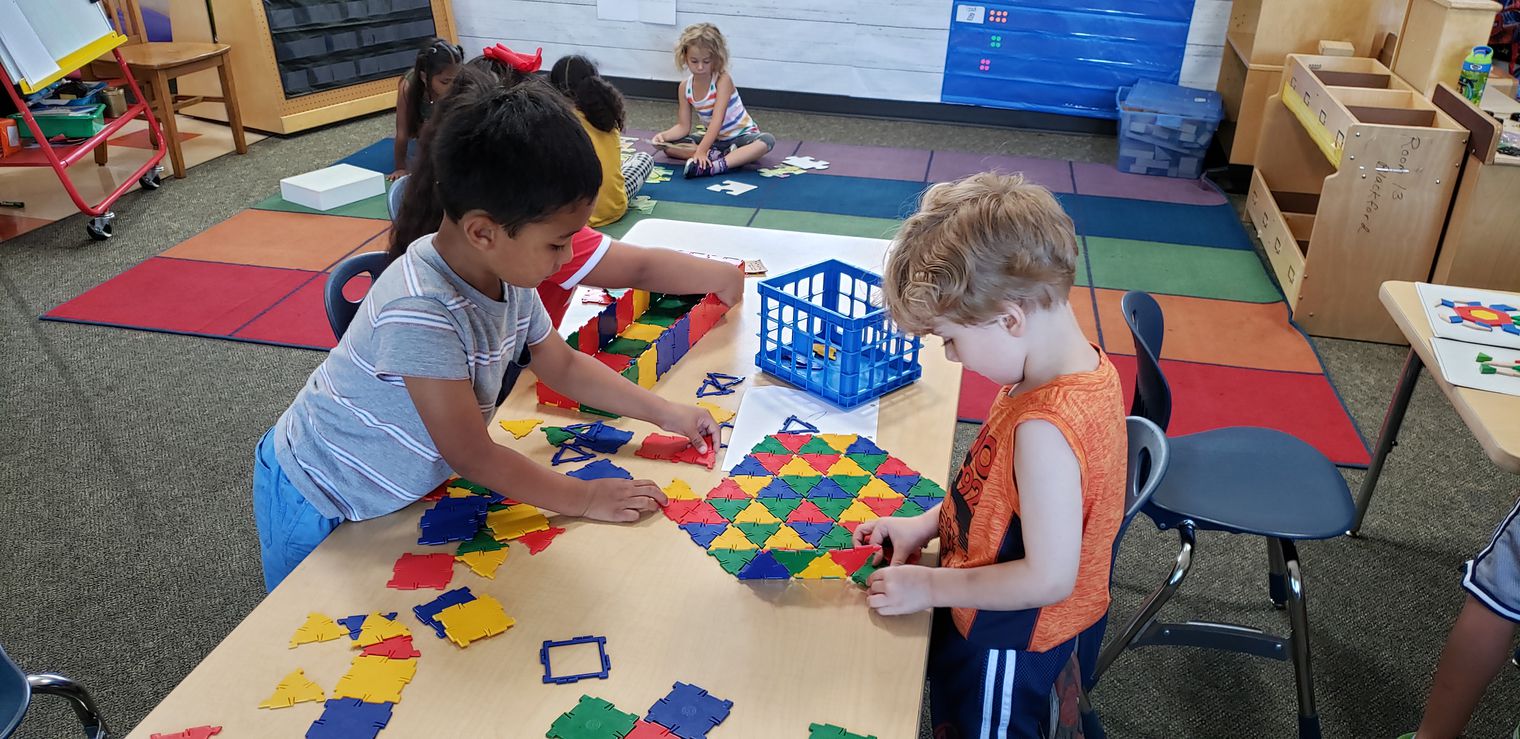 Two students working on a geometric math centers. 