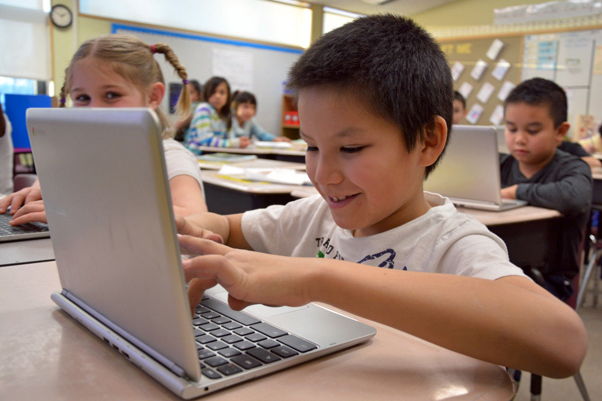 boy looking at laptop keyboard smiling