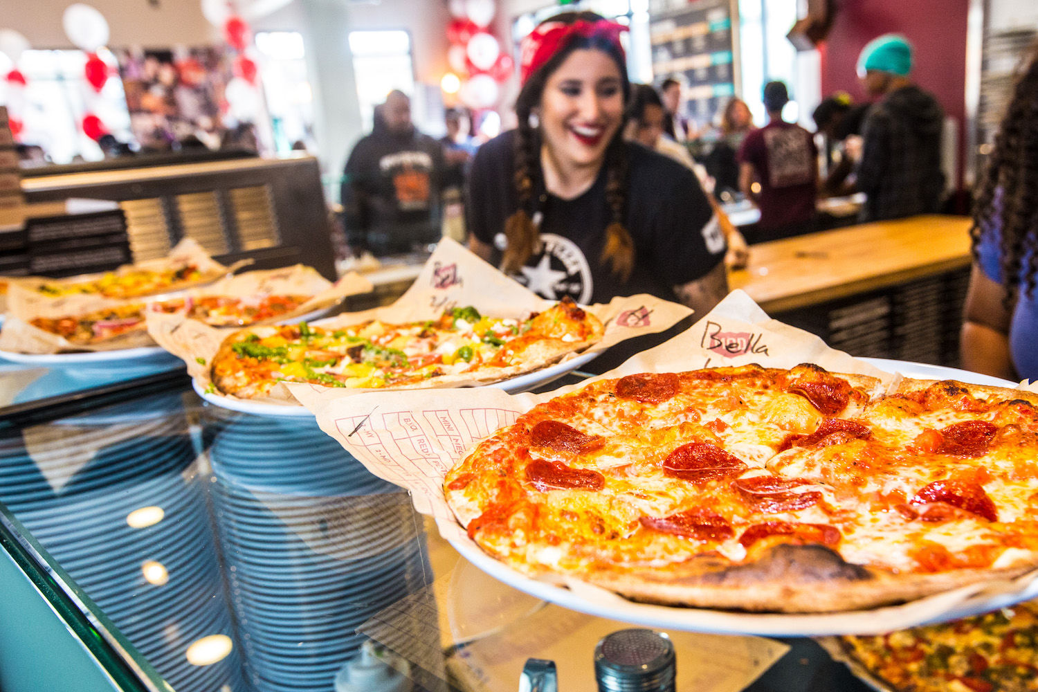 Picture of person next to pizzas