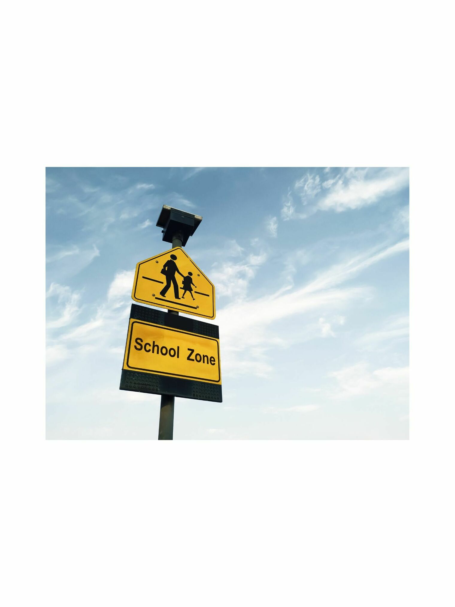 Picture of a yellow school zone crossing sign 
