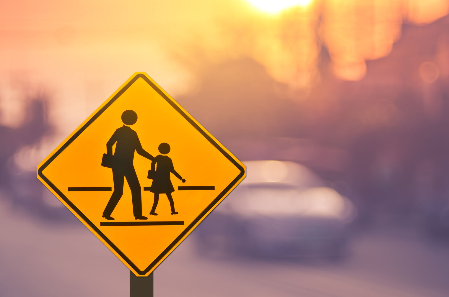 Crossing guard  sign with a silhouette  of a parent and student
